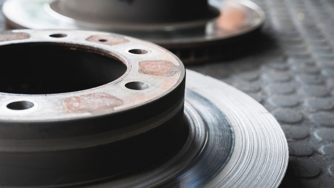 Worn and new brake rotors showing surface wear and corrosion that causes squealing brakes in Bad Boy Recoil utility vehicles