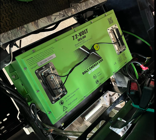 A green Bolt Energy USA 72-volt lithium battery pack installed in a vehicle